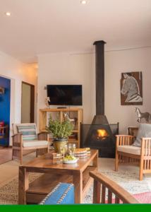 a living room with a fireplace and a table at Guest House Mooigezicht in Clarens