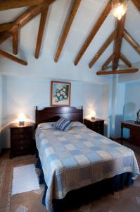 een slaapkamer met een bed met 2 nachtkastjes en 2 lampen bij El Cortijo at Molino la Ratonera in Zagra