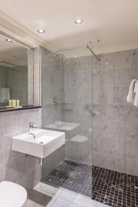 ein Bad mit einem Waschbecken und einer Dusche in der Unterkunft The Victoria Hotel in Galway