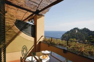 a balcony with a table and a view of the ocean at Splendido, A Belmond Hotel, Portofino in Portofino