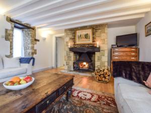 uma sala de estar com uma lareira de pedra e uma taça de fruta em Butts Farm em Cirencester