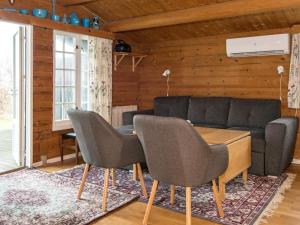 a living room with a couch and a table and chairs at 6 person holiday home in Grenaa in Grenå