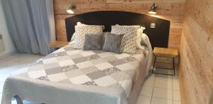 Un dormitorio con una cama grande con almohadas. en Chambres d'Hôtes des trouilles en Lafrançaise