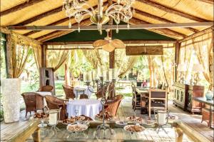 a dining room with tables and chairs and a chandelier at Layla Gocek Adults only in Göcek