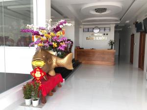um lobby de loja com um arranjo de flores em uma máscara em Hotel Đăng Khôi Núi Sam em Chau Doc