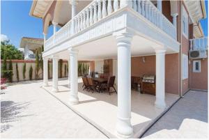 a patio with white columns and a table on a house at Villa SunShine Ciudad Quesada Spain in Ciudad Quesada