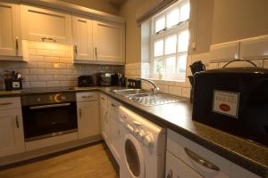 a kitchen with a sink and a dishwasher at Peveril Cottage - Darwin Lake Holiday Village in Matlock