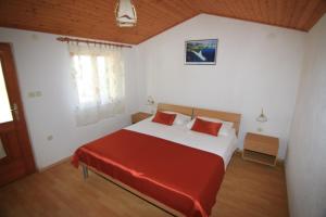 a bedroom with a large bed with a red blanket at Holiday home Ivan Bol in Bol