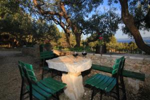 una mesa con tres sillas verdes y dos copas de vino en Holiday home Ivan Bol, en Bol