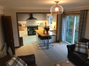 a kitchen and living room with a table and a couch at Glenlochy Apartments in Fort William