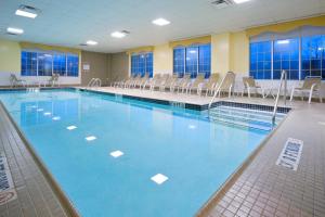 een groot zwembad met stoelen in een gebouw bij Holiday Inn Budd Lake - Rockaway Area, an IHG Hotel in Budd Lake