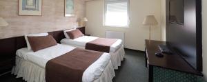 En eller flere senge i et værelse på Garni Hotel Oasis