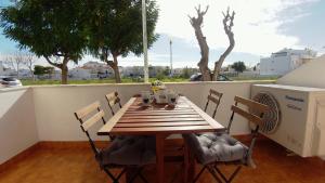 a wooden table and chairs on a balcony with a heater at Dream holidays @ Santa Luzia Tavira in Santa Luzia