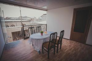 a table and chairs in a room with a balcony at Parivash Guest House in Bukhara