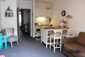 500 Miles Apartments في بون: مطبخ صغير مع طاولة وكراسي في الغرفة