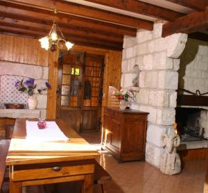 une cuisine avec une cheminée en pierre et une table en bois dans l'établissement Chalet les Eglantines, à Saint-Jacques-des-Blats