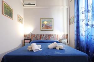 a bedroom with a blue bed with two pillows on it at casa ros via ostiense 73 in Rome
