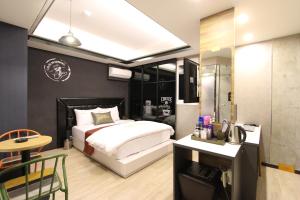 1 dormitorio con 1 cama y escritorio con ordenador en Line Motel en Daegu