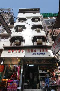 a tall white building with a store in front of it at Hotel Raj Inn Ajmer Sharif in Ajmer