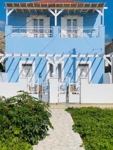 a blue and white building with a pathway in front at Pontamos Villas in Halki