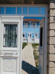 a door leading to a beach with a building at Pontamos Villas in Halki