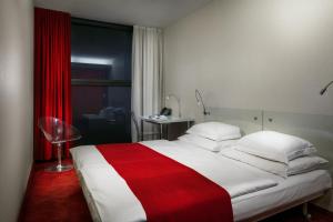 a bedroom with a bed with a red and white blanket at Design Metropol Hotel Prague in Prague