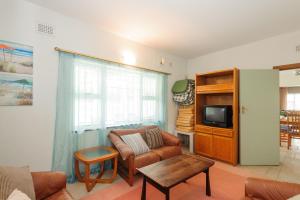 een woonkamer met een bank en een tv bij Comp Beach Road 55 - FAMILY ONLY - PET FRIENDLY in Ballito