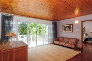 sala de estar con sofá y ventana grande en Comp Beach Road 55 - FAMILY ONLY - PET FRIENDLY, en Ballito