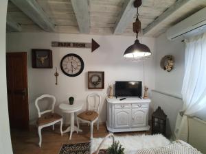 a living room with a tv and a table and chairs at Gasthaus Joó-Wellness Pension in Rábapaty