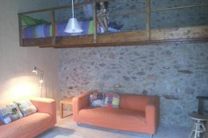 a living room with an orange couch and a loft at La casita marrón in Palafrugell +3 photos