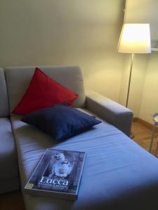 a book sitting on top of a bed with a couch at Guinigi Luxury Loft Historical Center of Lucca in Lucca
