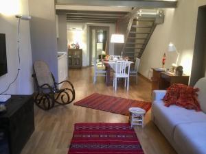 a living room with a couch and a dining room at Torre Guinigi Luxury Loft nel centro storico di Lucca in Lucca