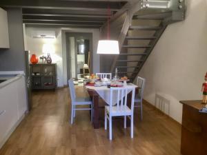a kitchen and dining room with a white table and chairs at Torre Guinigi Luxury Loft nel centro storico di Lucca in Lucca +19 photos