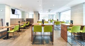 a waiting room with green chairs and tables at numberOne Hotel in Nuremberg