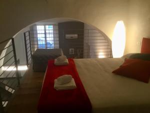 a bedroom with a bed with two towels on it at Torre Guinigi Luxury Loft nel centro storico di Lucca in Lucca