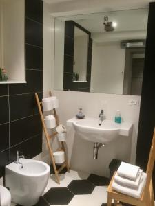 a bathroom with a sink and a toilet and a mirror at Torre Guinigi Luxury Loft nel centro storico di Lucca in Lucca