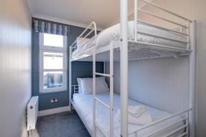 1 Schlafzimmer mit 2 Etagenbetten und einem Fenster in der Unterkunft Sea Breeze - Aldeburgh Coastal Cottages in Sizewell