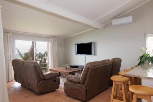 a living room with chairs and a table and a television at Comp Beach Road 25 - FAMILY ONLY in Ballito