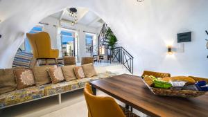 a living room with a couch and a table and chairs at PLAZAsuite1600 in Rethymno