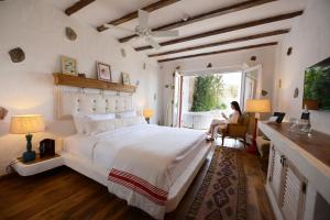 a woman sitting in a chair in a bedroom with a bed at Hotel Unique-Boutique Class - Adults Only in Fethiye