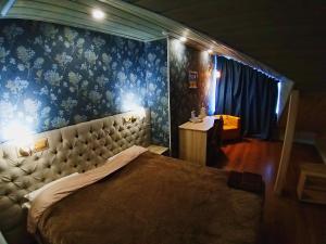 1 dormitorio con 1 cama grande y pared azul en Hotel Pushkin, en Pskov