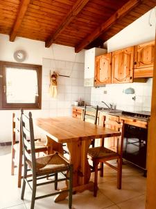 een keuken met een houten tafel en stoelen bij Il residence della salute in Montese