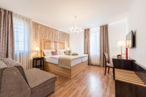 um quarto de hotel com uma cama e um sofá em Plitvice Falls Cottage em Plitvica selo
