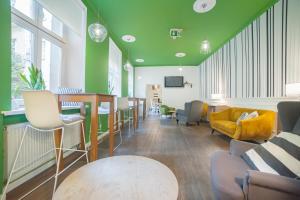 a living room with green walls and chairs at Dizzy Daisy Hostel in Kraków