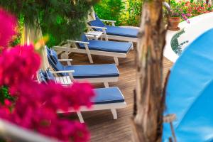 a row of blue chairs on a deck with flowers at Hotel Unique-Boutique Class - Adults Only in Fethiye
