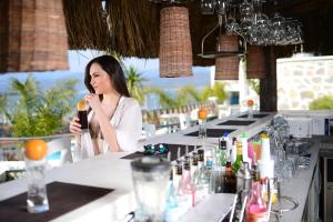 a woman sitting at a bar holding a drink at Hotel Unique-Boutique Class - Adults Only in Fethiye