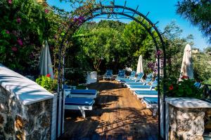 an arch with chairs and umbrellas in a garden at Hotel Unique-Boutique Class - Adults Only in Fethiye