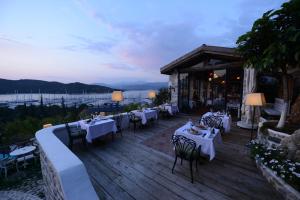 a restaurant with tables and chairs on a wooden deck at Hotel Unique-Boutique Class - Adults Only in Fethiye