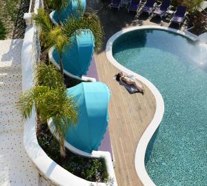 a swimming pool with palm trees in a resort at Hotel Unique-Boutique Class - Adults Only in Fethiye