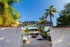 a sign for a hotel doahuilla suites with palm trees at Hotel Boquilla Suites By GEH Suites in Cartagena de Indias